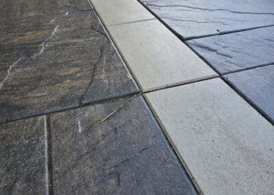 Textured concrete pavers in dark and light tones featuring a natural stone look.