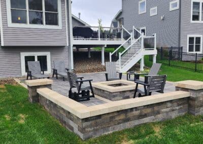 Cozy backyard fire pit with seating area surrounded by landscaped lawn and houses.